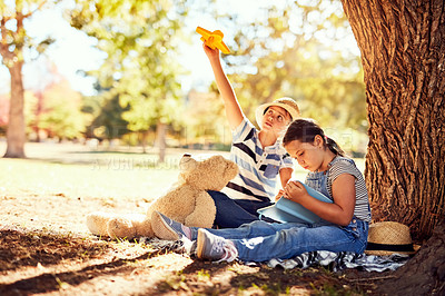 Buy stock photo Shot of two little siblings having fun while sitting on a blanket at the park