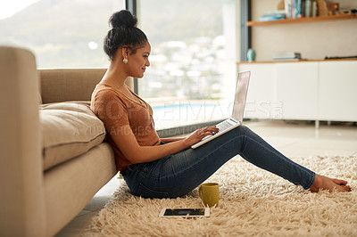 Buy stock photo Shot of a young woman using a laptop at home