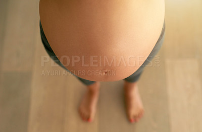 Buy stock photo Cropped high angle shot of a pregnant woman’s bare belly