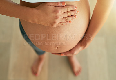 Buy stock photo Cropped high angle shot of a pregnant woman holding her bare belly