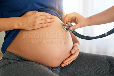 Buy stock photo Cropped shot of a doctor doing a checkup on a pregnant woman with a stethoscope