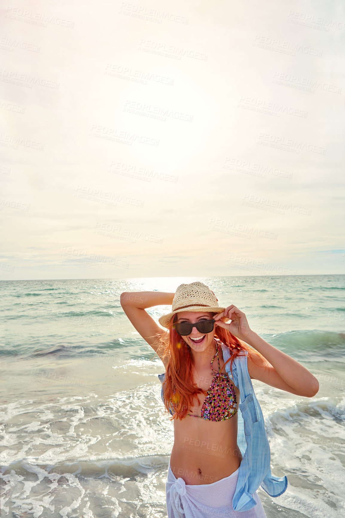 Buy stock photo Portrait an attractive young woman enjoying a day at the beach