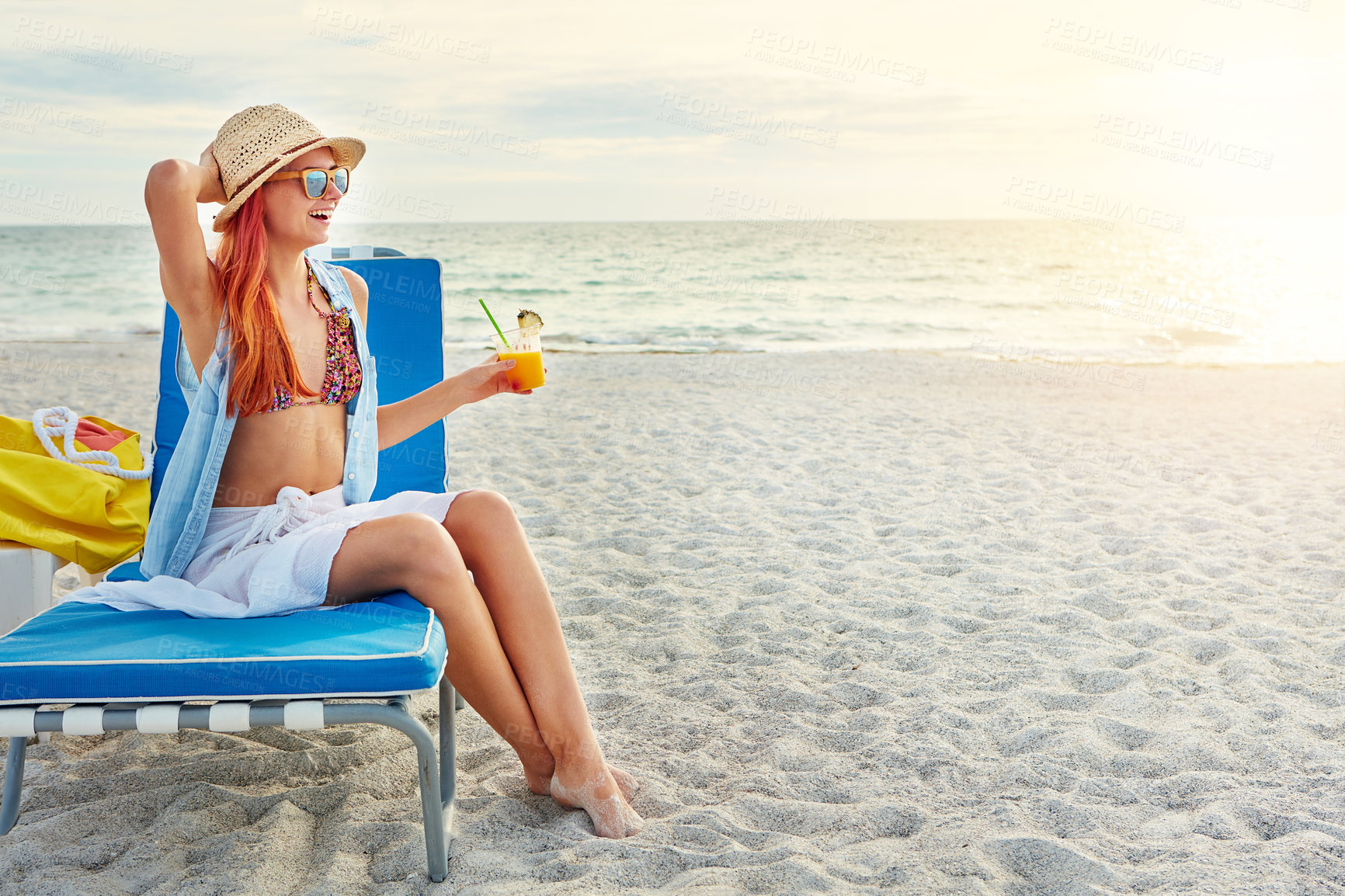 Buy stock photo Beach, chair and happy woman with fruit cocktail on holiday, travel and summer vacation outdoor on island in Greece. Sea, laugh and girl in bikini with alcohol drink while thinking at ocean to relax