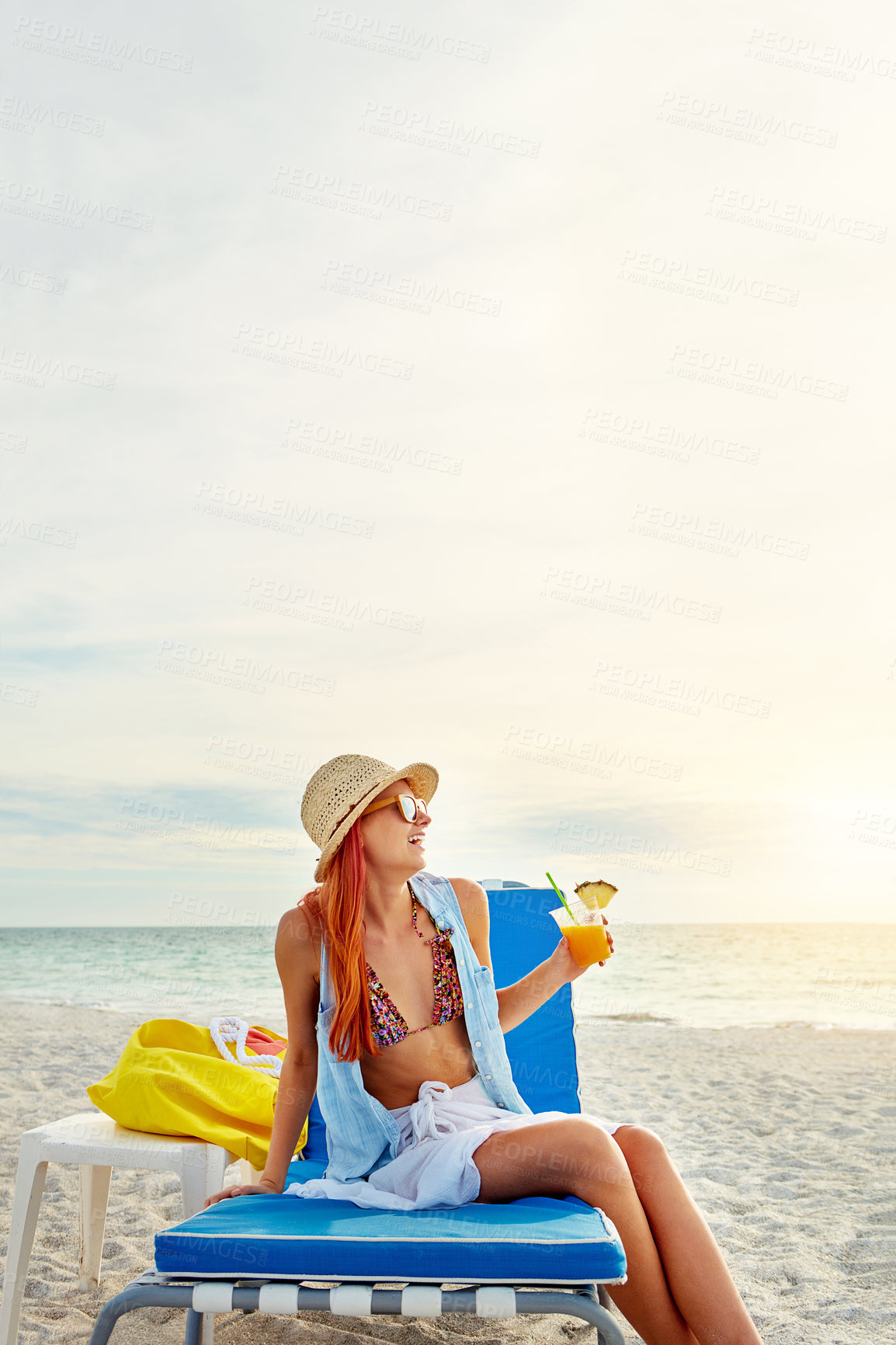 Buy stock photo Beach, relax and happy woman with fruit cocktail on holiday, travel or summer vacation outdoor on island in Greece. Sea, laughing and girl in bikini with alcohol drink at ocean mockup space on chair