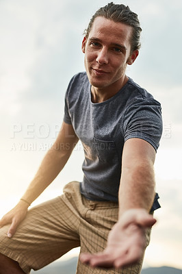 Buy stock photo Portrait of a friendly young hiker holding his hand out in a helpful gesture