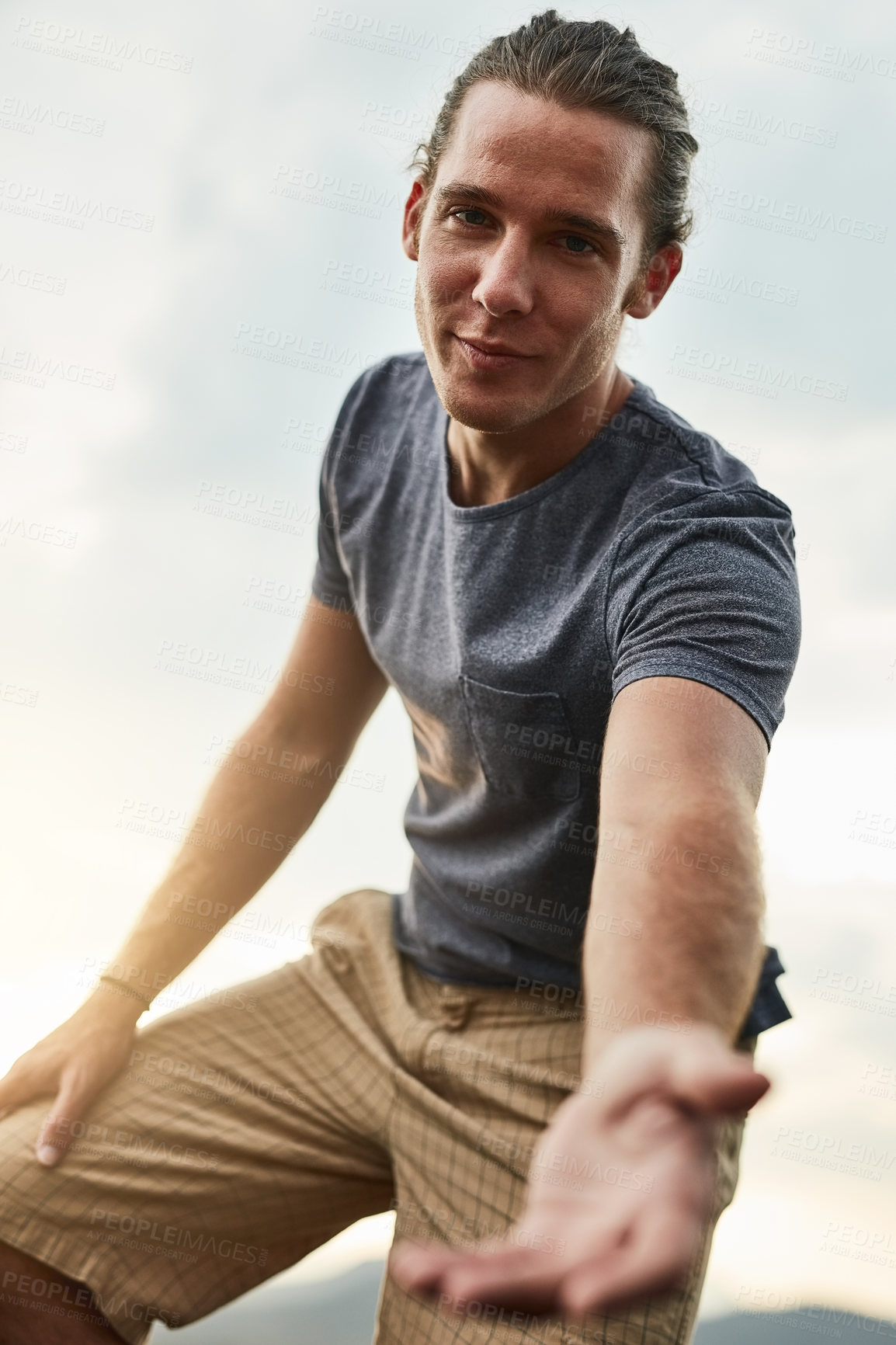 Buy stock photo Portrait of a friendly young hiker holding his hand out in a helpful gesture