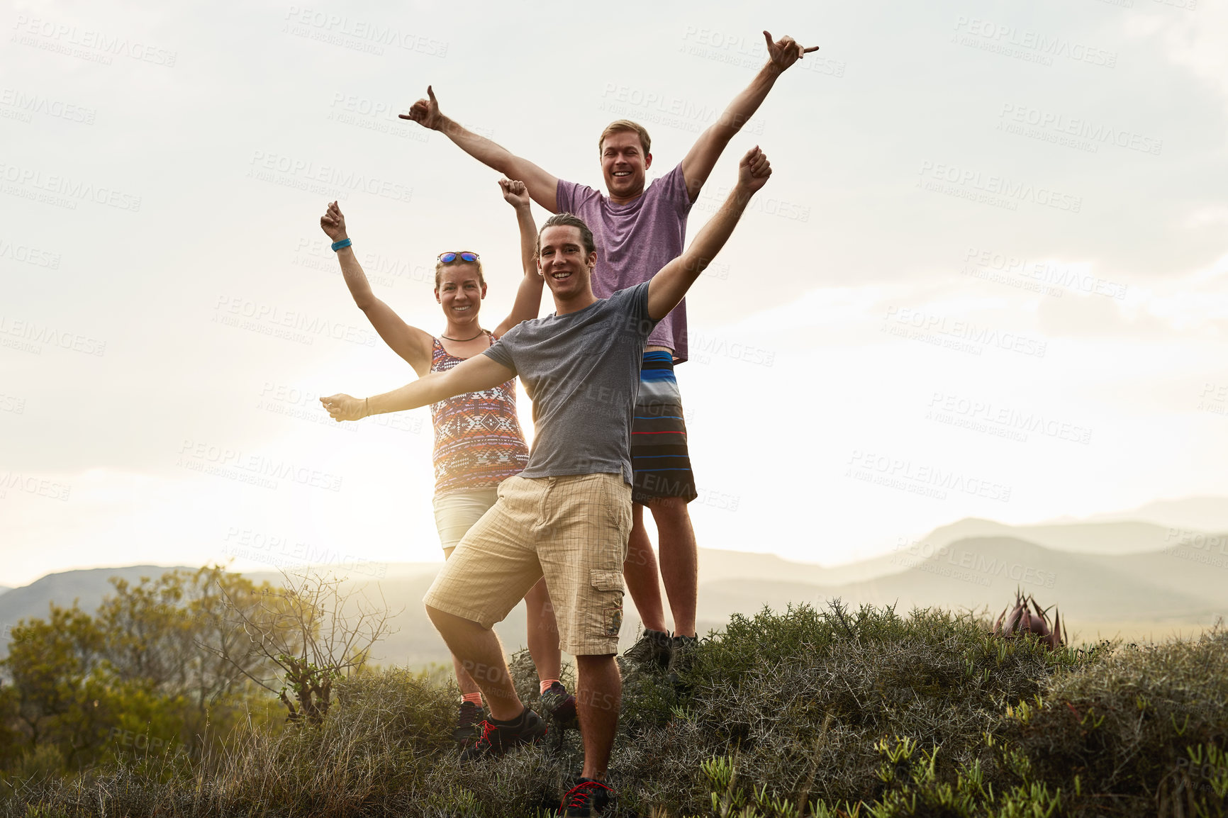 Buy stock photo Portrait of three happy friends posing together during a hike in the mountains