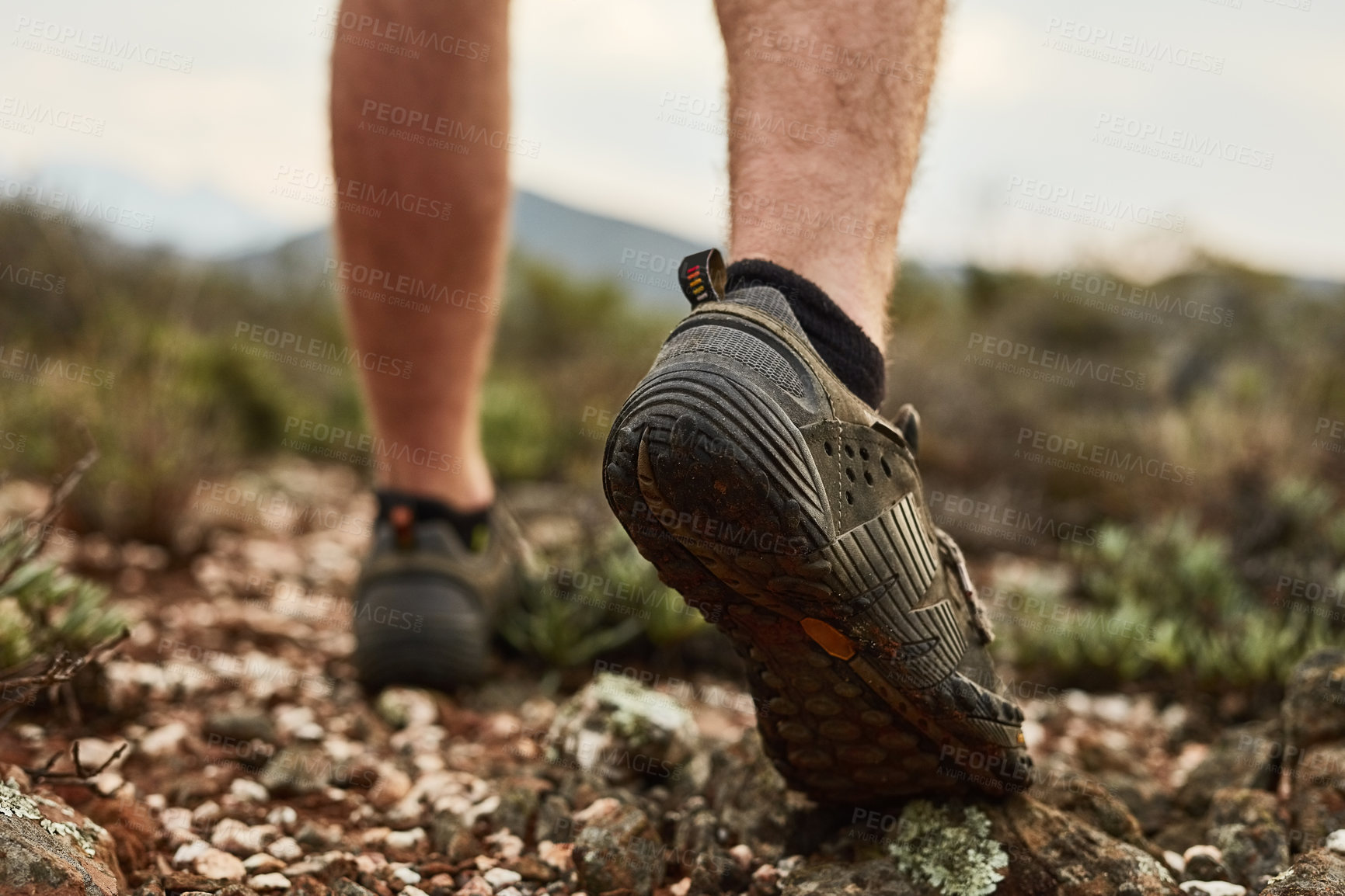 Buy stock photo Cropped shot of an unidentifiable young hiker's feet walking on a mountain trail