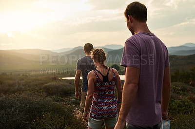 Buy stock photo Friends, people hiking and trekking in nature with fitness, bond in countryside with travel together and freedom. Exercise, adventure with men and woman walking through meadow or field with back view