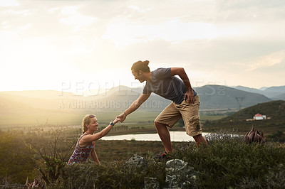 Buy stock photo Man helping woman while hiking, fitness and couple outdoor trekking in nature or countryside for exercise and travel. Young people hike together, support and adventure with date, bonding and workout