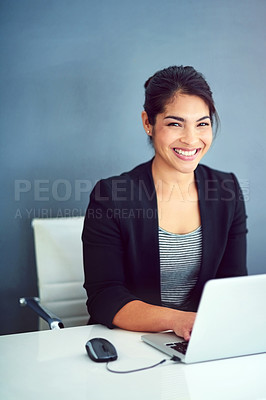 Buy stock photo Portrait of a happy young businesswoman working behind her laptop in the office