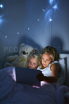 Buy stock photo Tablet, bed and kids in home at night for streaming movie, video or cartoon together. Digital technology, girl and children in bedroom for game, learning and sisters reading story online to relax