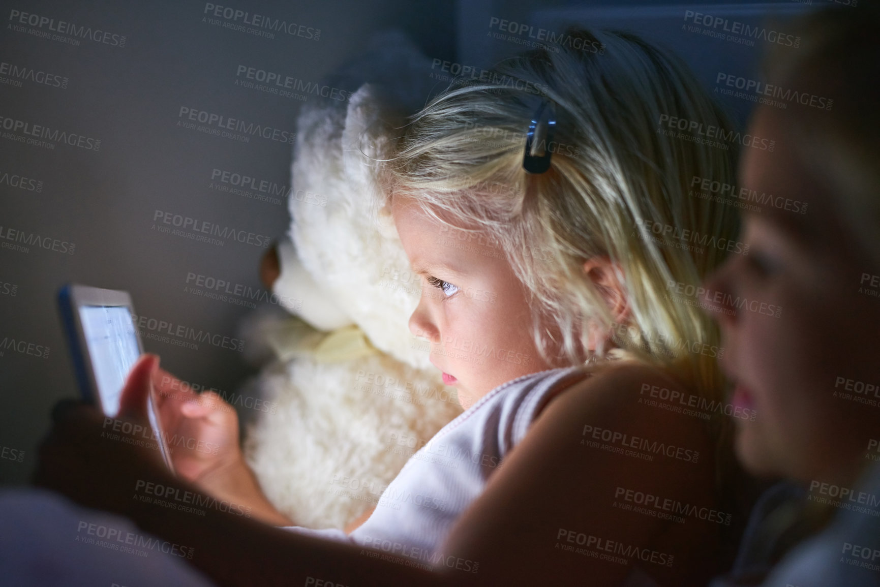 Buy stock photo Shot of two little girls using a digital tablet before bedtime