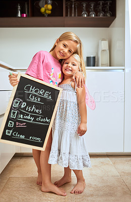 Buy stock photo Portrait of two little girl holding a chalkboard with a completed list of chores at home