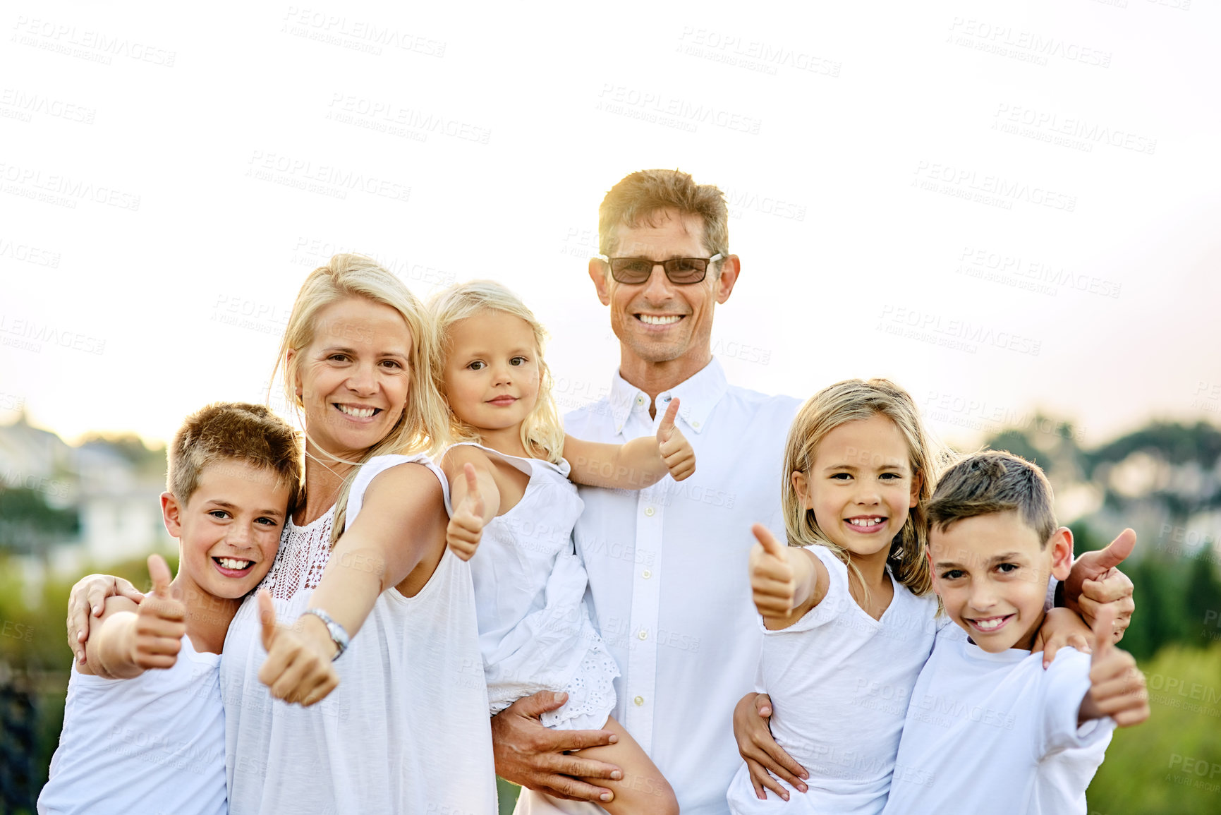 Buy stock photo Shot of a happy family with their thumbs up outdoors