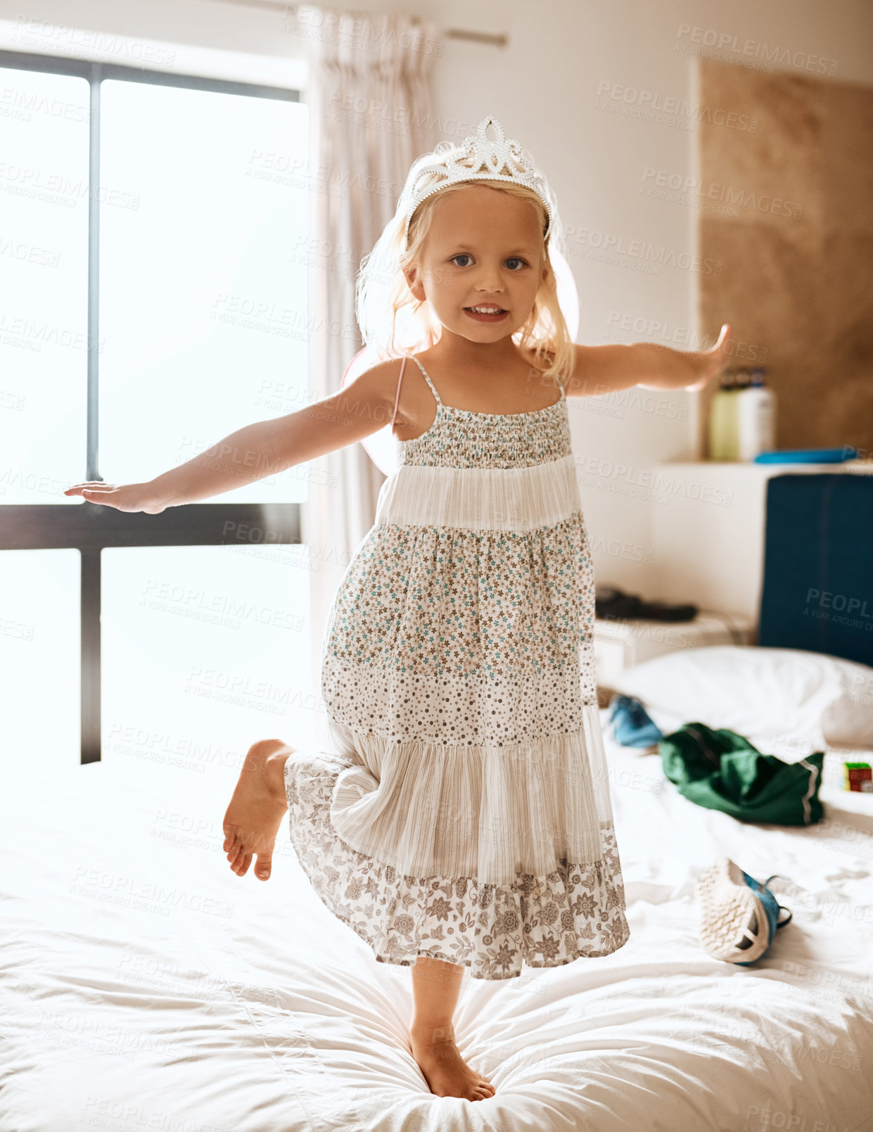 Buy stock photo Portrait of an adorable little girl jumping on the bed at home