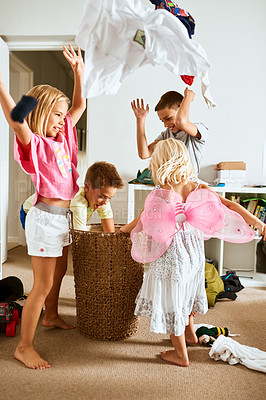 Buy stock photo Shot of little siblings throwing laundry in the air at home