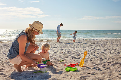 Buy stock photo Shot of a young family enjoying a summer day out at the beach