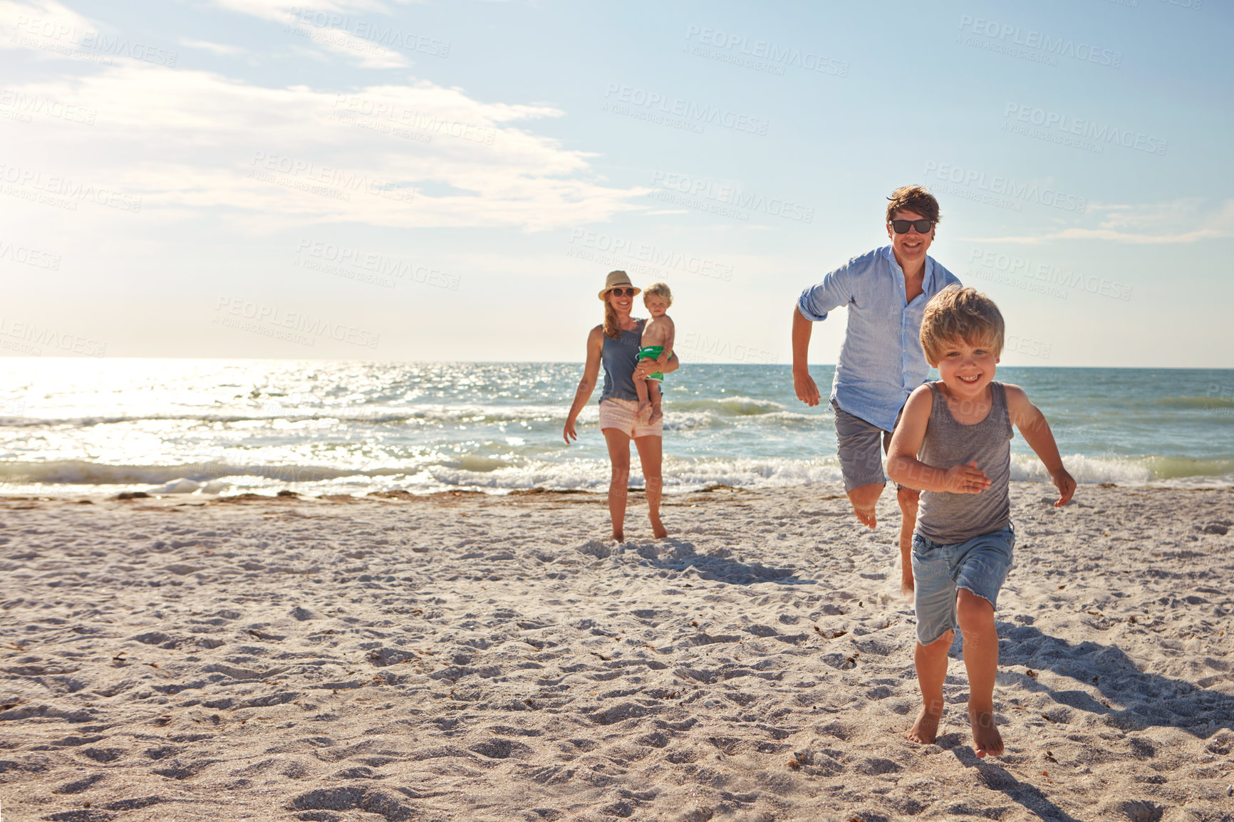 Buy stock photo Happy, family and children playing on the beach on holiday, travel or adventure in summer. Boy, father and kids with parents and outdoor ocean for fun energy and happiness with a game while running