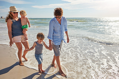 Buy stock photo Shot of a young family enjoying a summer day out at the beach