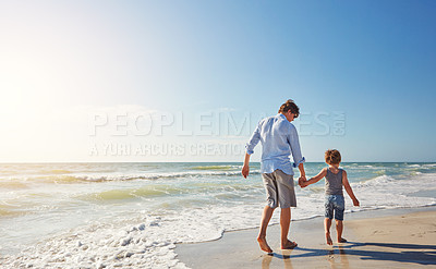 Buy stock photo Shot of a young man and his son enjoying a summer day out at the beach