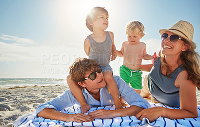 Buy stock photo Picnic, piggyback or children with family at beach on holiday vacation or weekend together with parents. Father, mother or happy kids siblings at sea for bonding or playing by ocean in Spain to relax