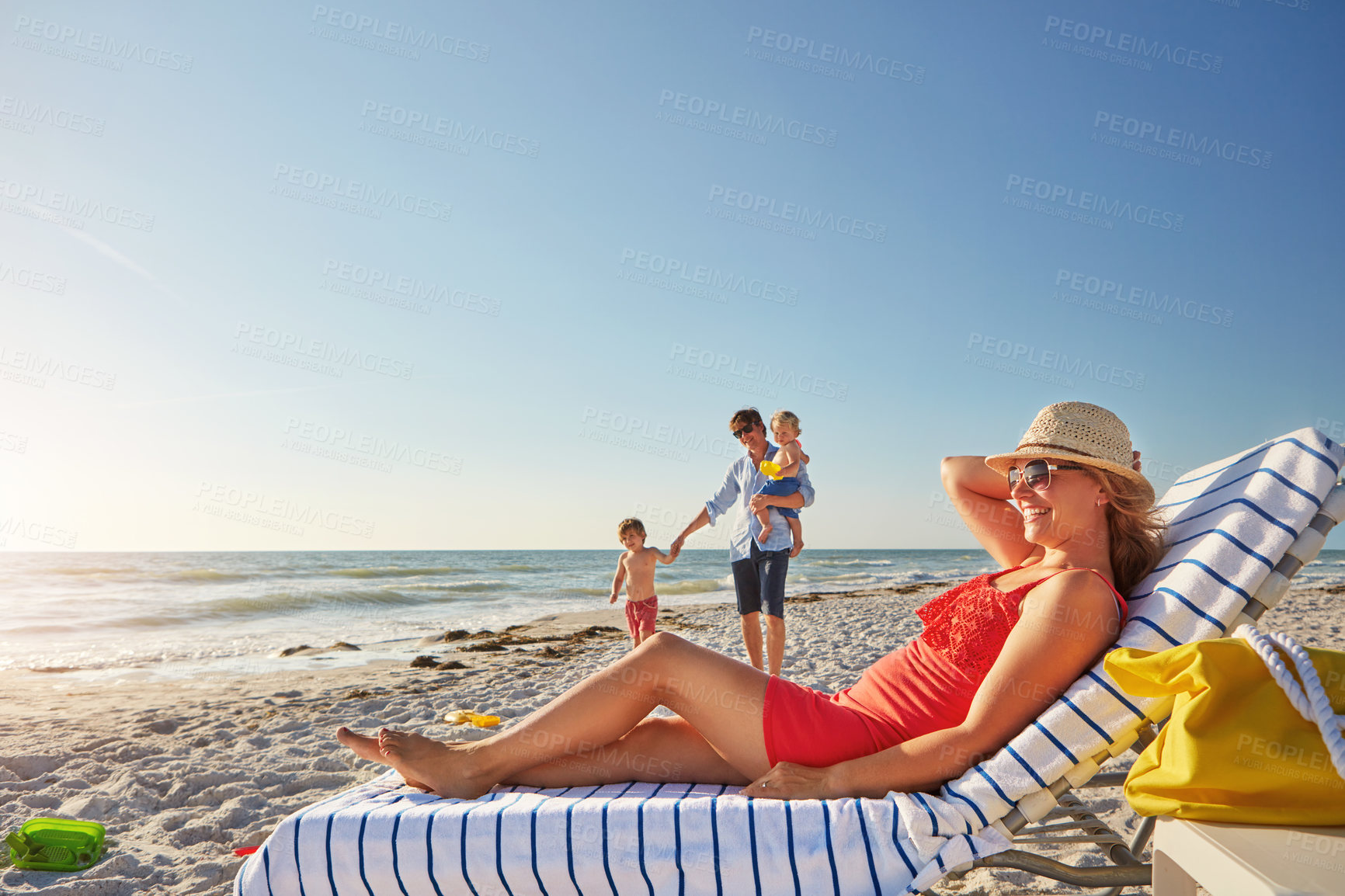 Buy stock photo Woman, blue sky and relax on beach chair with family together, adventure and bonding in summer holiday. Happy, mother and sunglasses by ocean, travel and freedom for tropical vacation in Greece