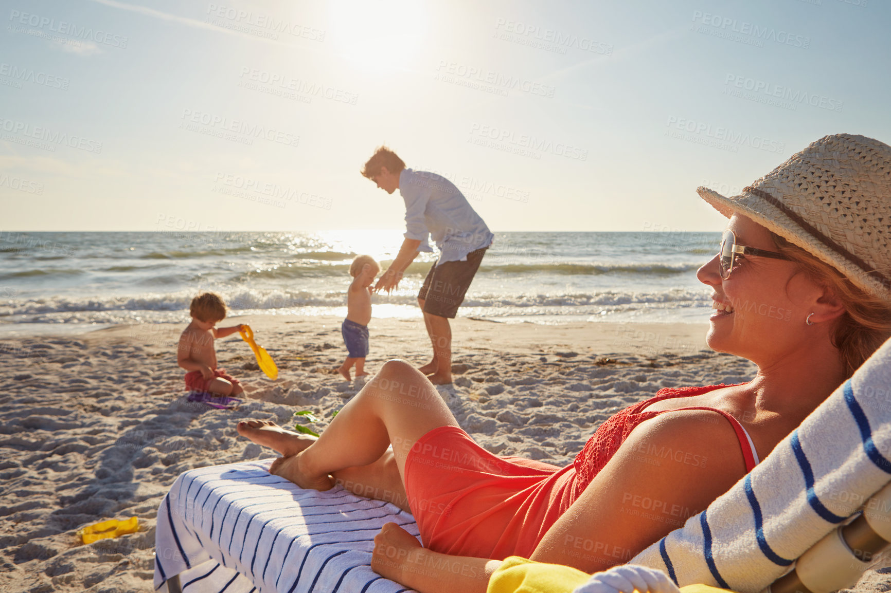 Buy stock photo Chair, relax or children with woman at beach on holiday vacation or weekend together with dad or family. Father, calm mother or kids siblings at sea for bonding or break in nature in Spain in summer 