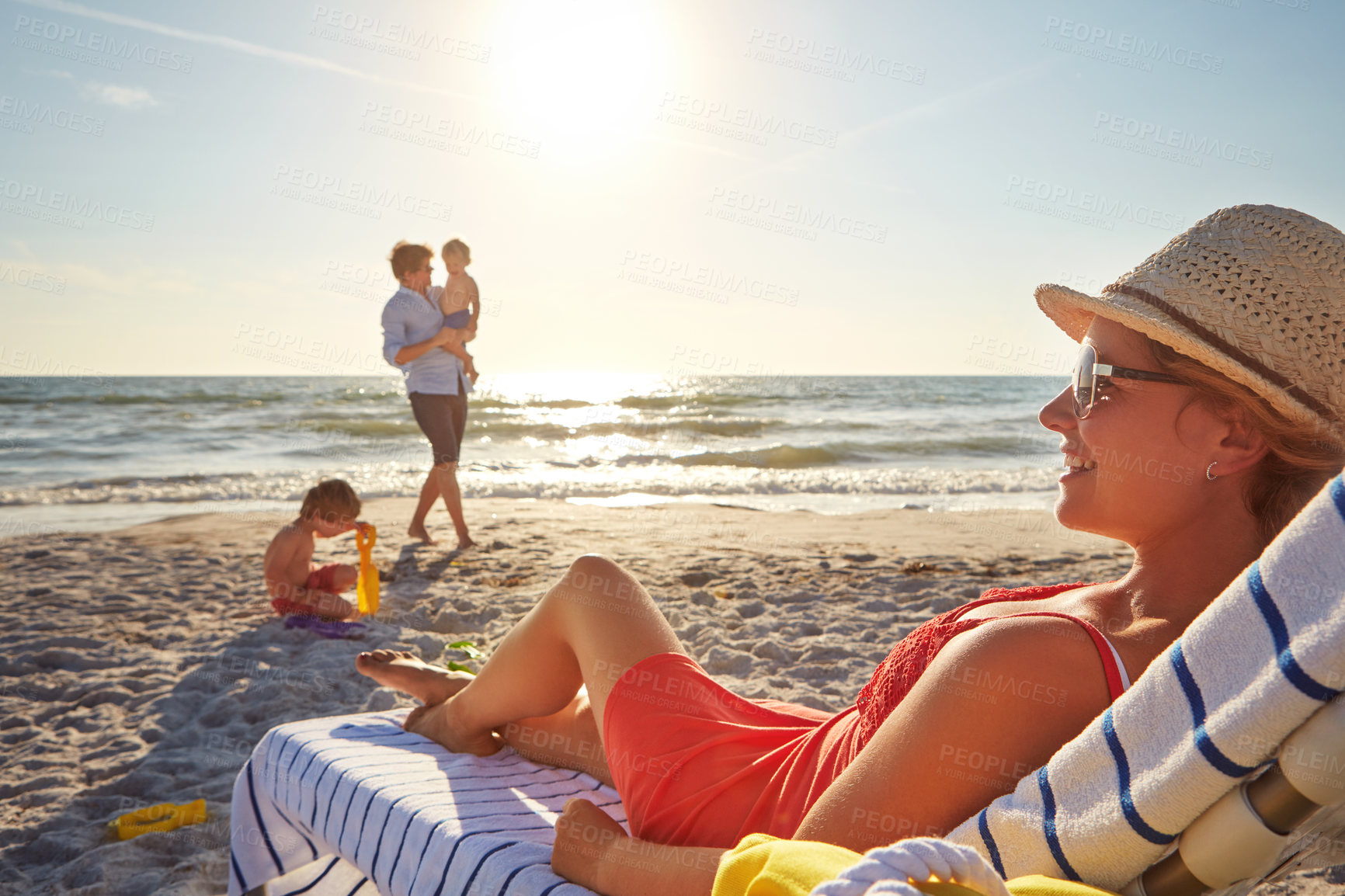 Buy stock photo Chair, relax or kids with happy woman at beach on holiday vacation or weekend together with dad or family. Father, calm mother and children siblings at sea for bonding or break in nature in Spain