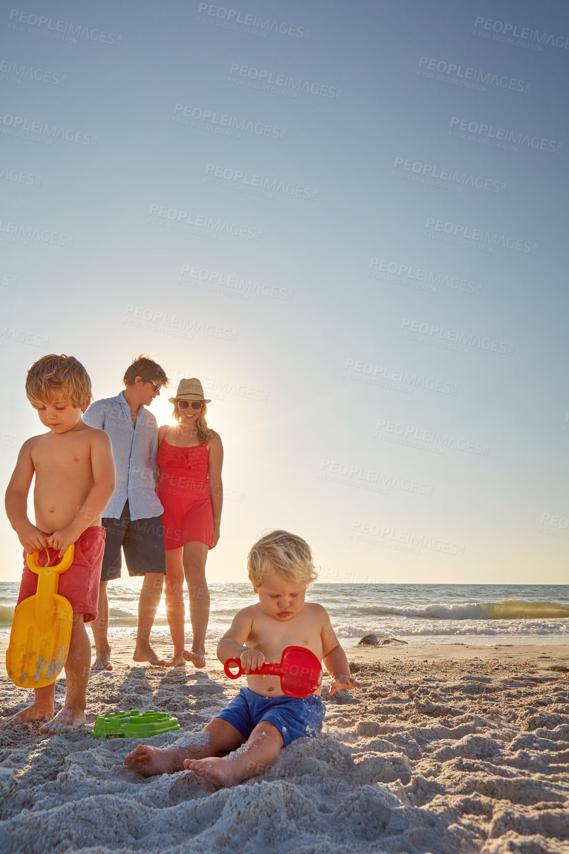 Buy stock photo Love, family and children building sand castle on beach for holiday, travel or vacation together. Mother, father and kids outdoor on island coast in summer for adventure, bonding or development