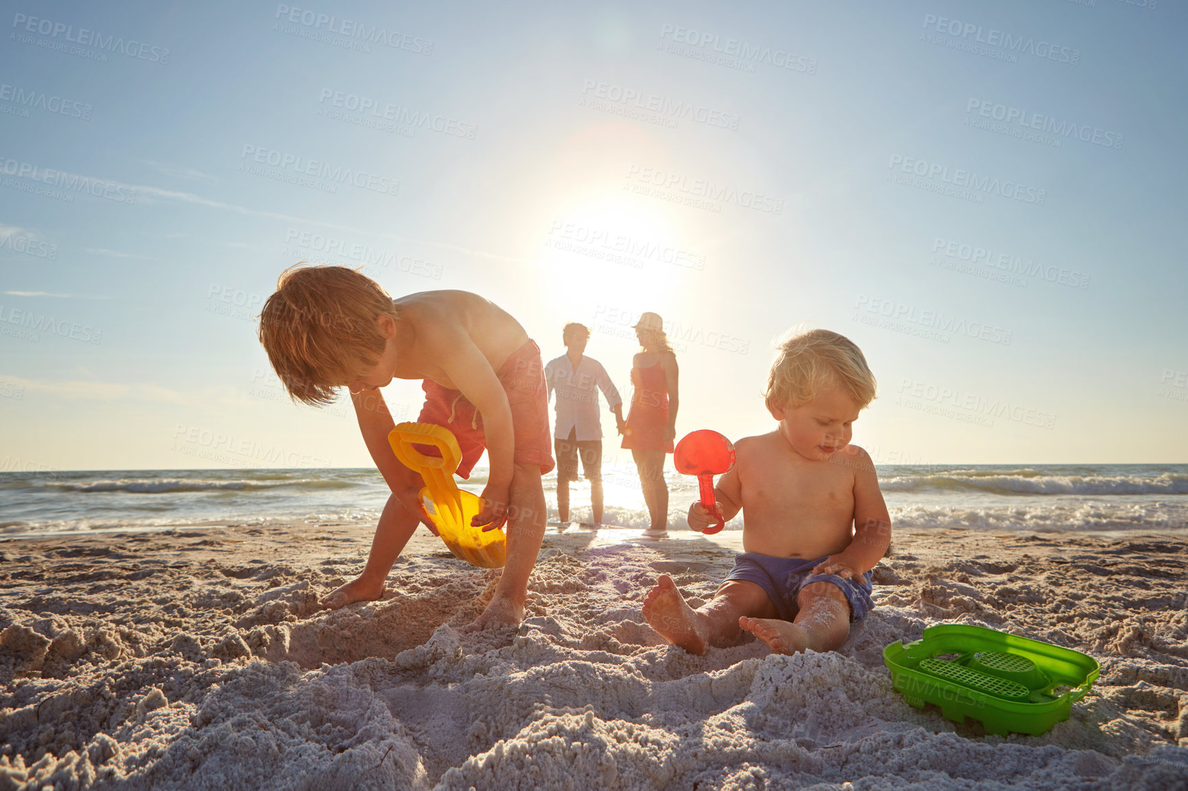 Buy stock photo Beach, family and kids with sand castle in summer for holiday, travel or vacation together. Mother, father and children playing outdoor on tropical island coast for adventure, bonding or development