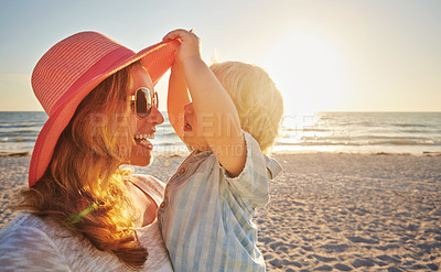 Buy stock photo Happy mother, kid and beach with hug in sunset for outdoor holiday, weekend or bonding in nature. Mom, child and little boy with smile for embrace, love or care in sunshine by ocean coast or sea