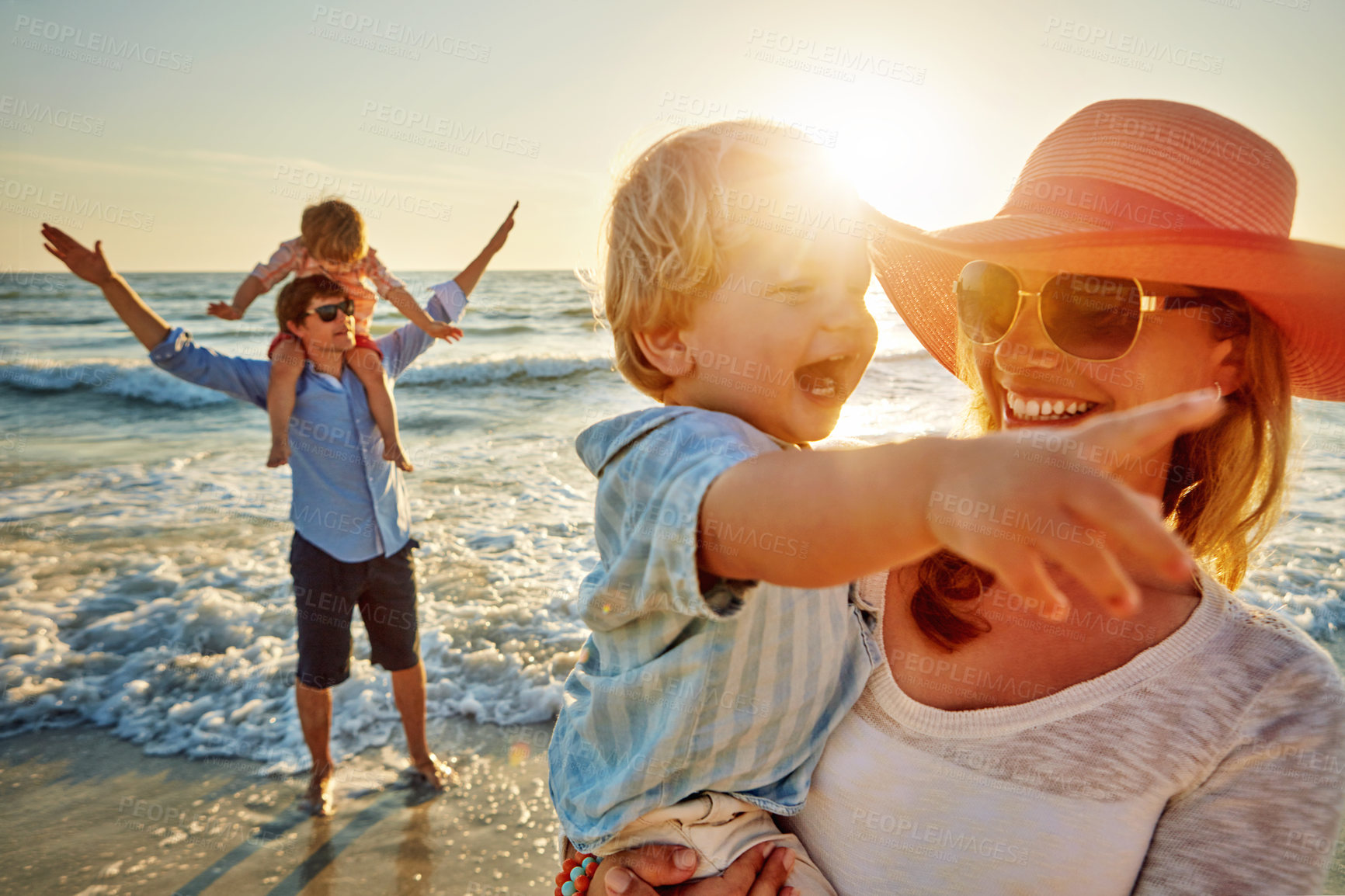 Buy stock photo Happy family, mother and beach with little boy for bonding, outdoor holiday or weekend in nature sunset. Mom, father or children with smile for embrace, love or care in sunshine by ocean coast or sea