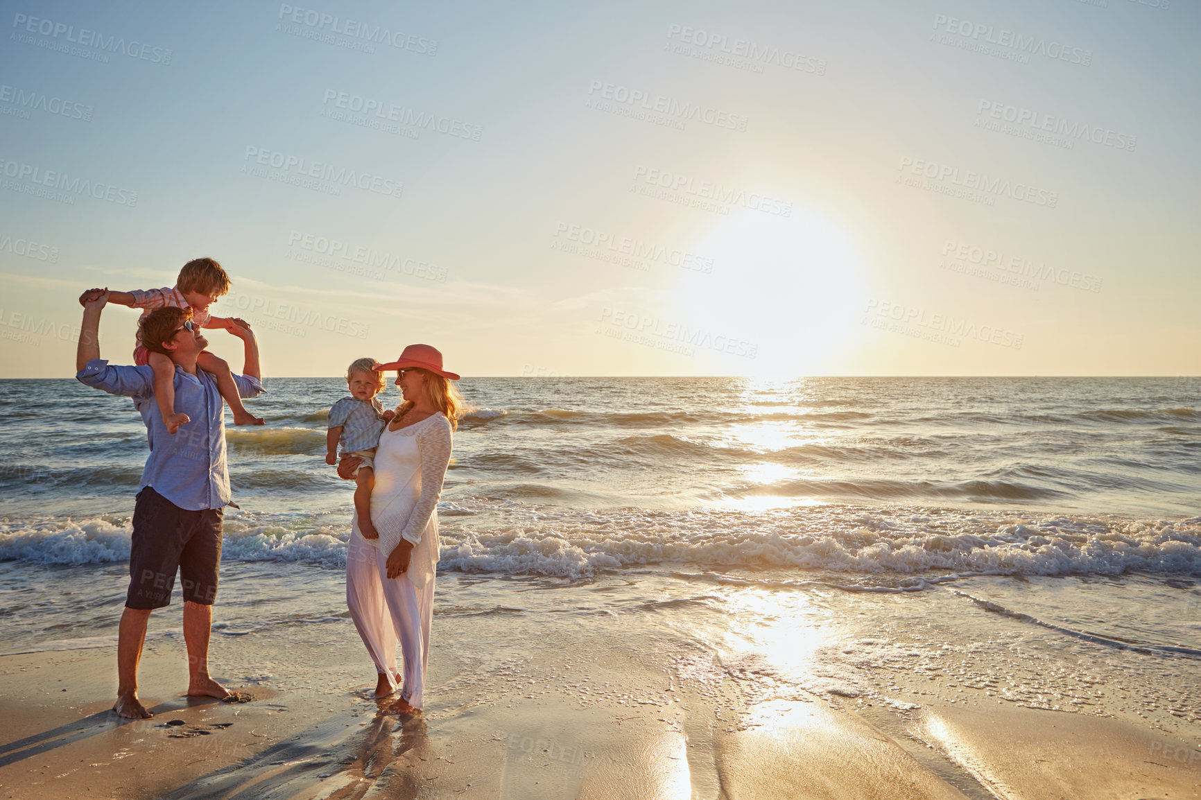 Buy stock photo Family, parents and beach with kids for bonding, outdoor holiday or weekend in nature or sunset. Mom, father or people playing with young children for embrace, love or care in sunshine by ocean coast