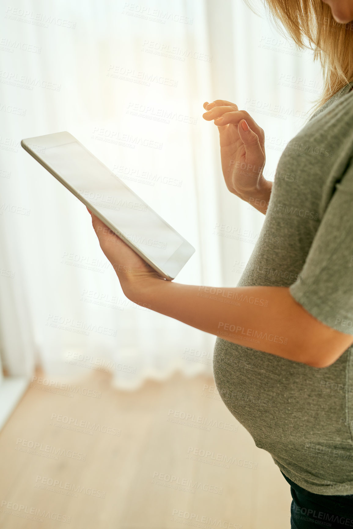 Buy stock photo Cropped shot of a pregnant woman using her digital tablet at home