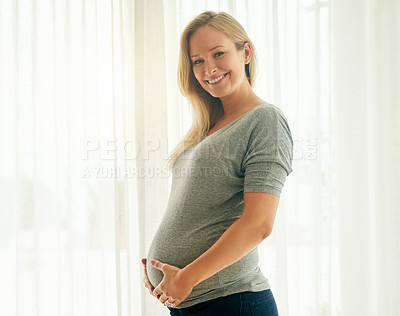 Buy stock photo Shot of a beautiful woman holding on to her pregnant belly