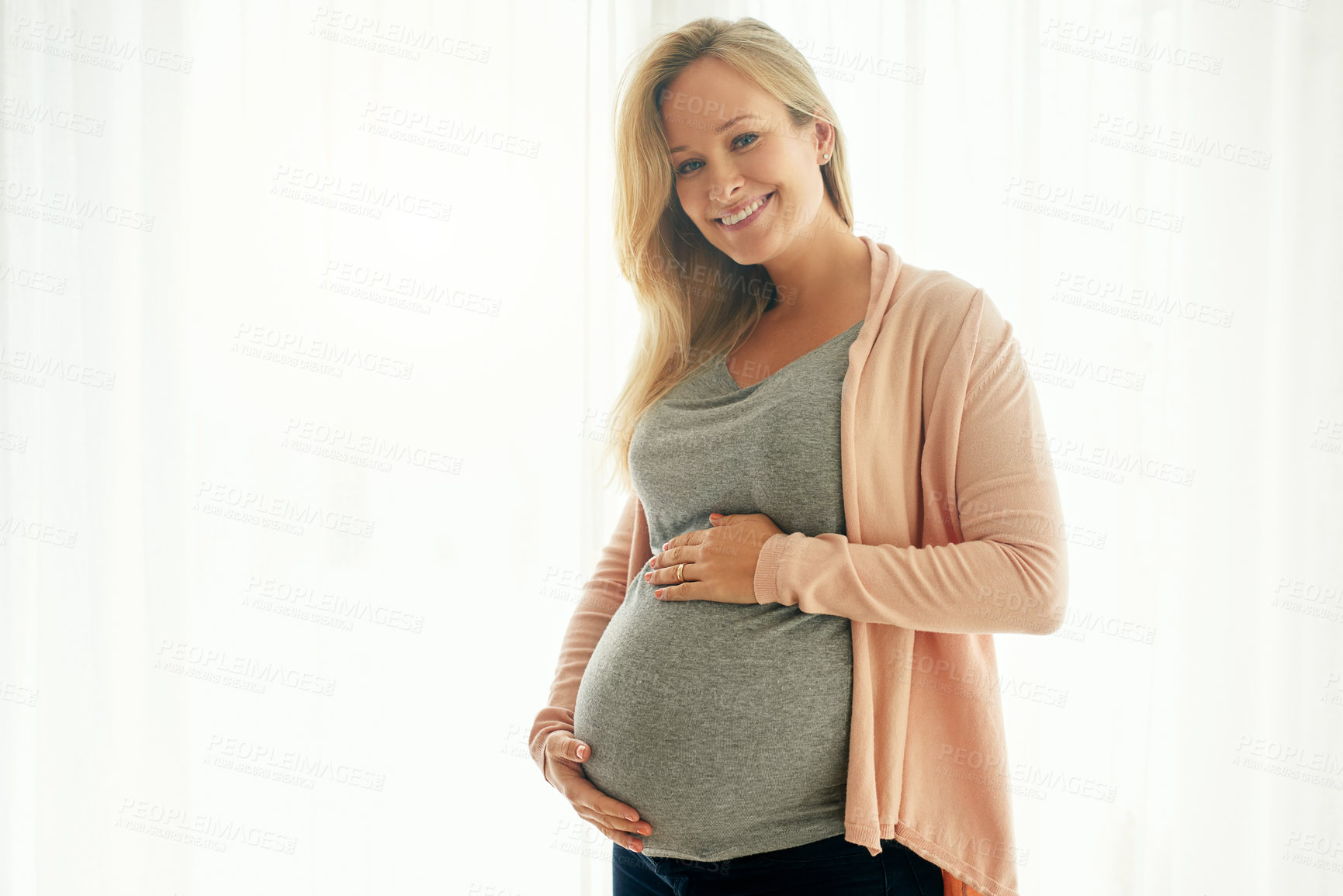 Buy stock photo Shot of a beautiful woman holding on to her pregnant belly