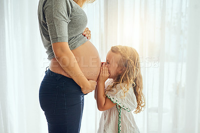 Buy stock photo Cropped shot of a little girl whispering to her mother's pregnant belly