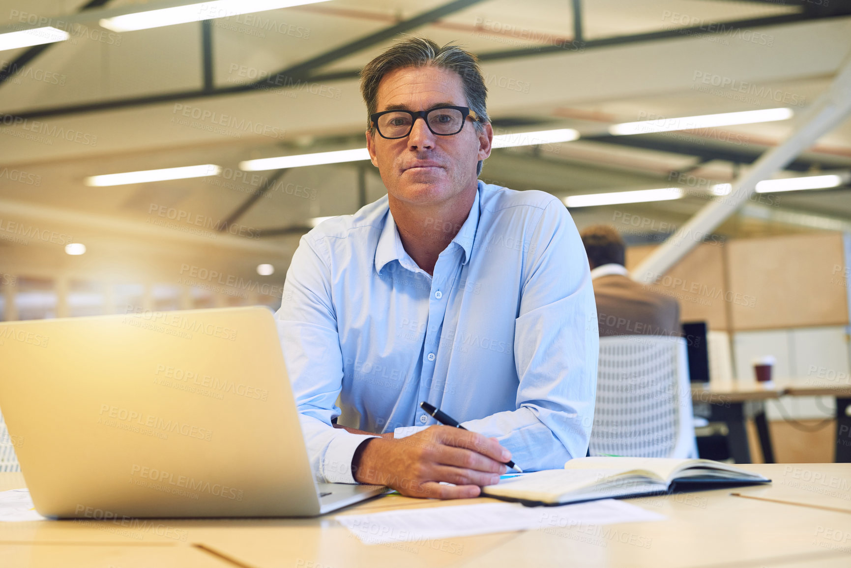 Buy stock photo Portrait of a hardworking businessman working on his laptop in the office