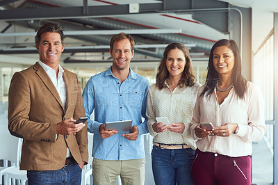 Buy stock photo Portrait of a team of businesspeople posing with their wireless devices in the office