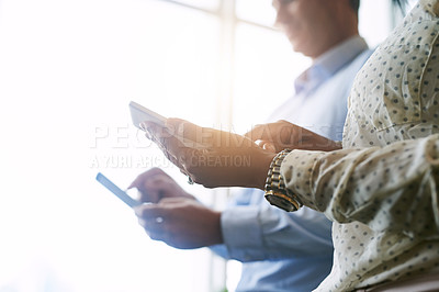 Buy stock photo Closeup shot of two unrecognisable businesspeople using digital devices in an office