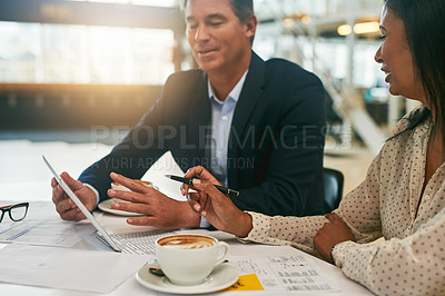 Buy stock photo Shot of two businesspeople working together on a digital tablet in an office