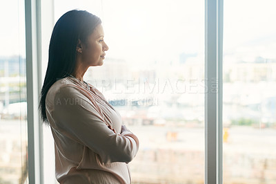 Buy stock photo Shot of a businesswoman looking out the window in an office
