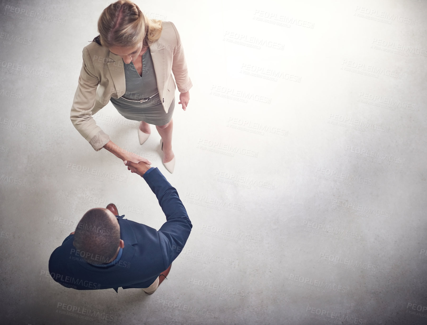 Buy stock photo High angle shot two professional businesspeople shaking hands in the office