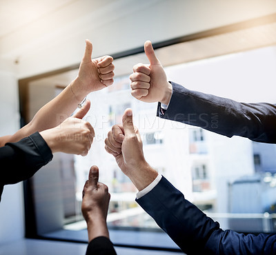 Buy stock photo Cropped shot of a team of unidentifiable businesspeople showing thumbs up together in the office