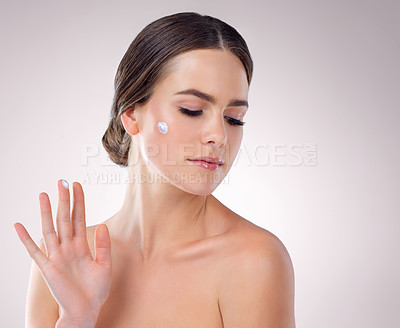 Buy stock photo Woman, finger and studio for moisturizing cream, beauty and cosmetics lotion for even skin tone. Female person, dermatology and hydration glow on gray background, sunscreen and thinking on benefits