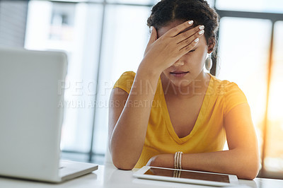 Buy stock photo Shot of a young designer looking stressed out while working in an office