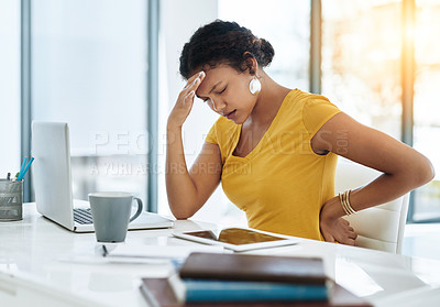 Buy stock photo Shot of a young designer suffering with a headache and back pain in an office