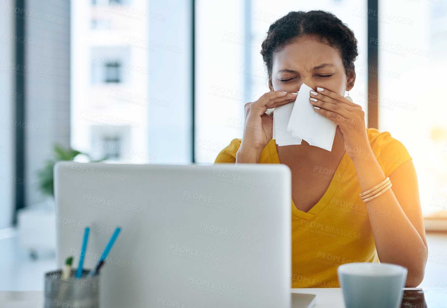 Buy stock photo Shot of a young designer blowing her nose in an office