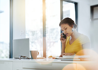Buy stock photo Shot of a young designer talking on a cellphone while working in an office